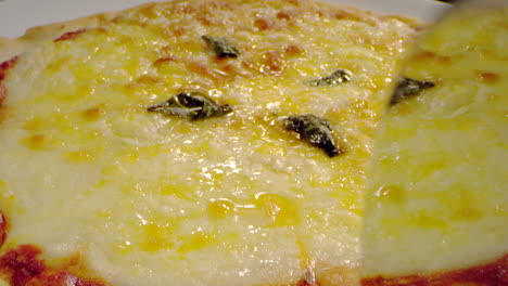 toma macro cortando pizza con queso y salsa de tomate