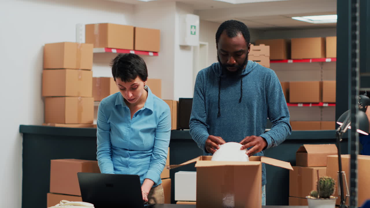 Two employees preparing packages in a warehouse