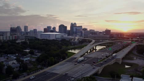 Umlaufende-Drohnenaufnahme-Der-Innenstadt-Von-Orlando-Bei-Sonnenaufgang,-Wunderschönes-Rotes-Aufflackern-Vom-Goldenen-Sonnenaufgang