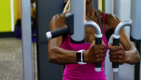 mujer en forma haciendo ejercicio en la máquina de mosca pec