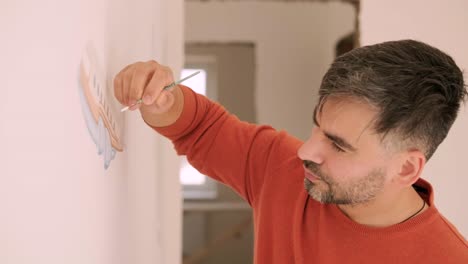 el artista está decorando las paredes con dibujos en la habitación de los niños. pintura de arte de las paredes en la casa nueva. trabajos de reparación.