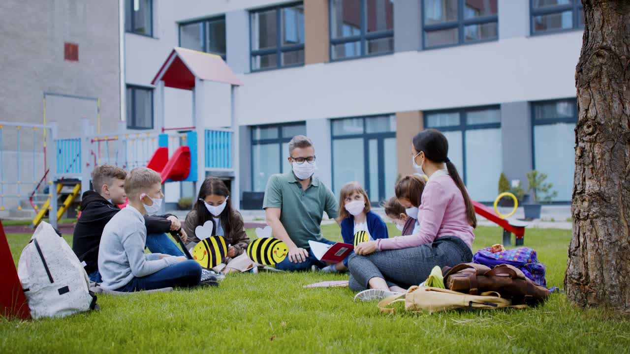 grupo de niños alegres aprendiendo al aire libre en la escuela después de la cuarentena y el bloqueo de covid-19.