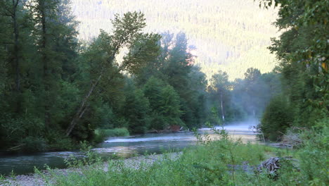 river b-roll: fog rises from early morning mountain river in shadow