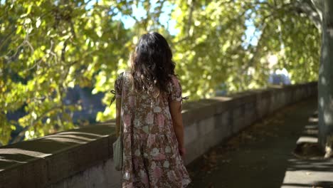 video of a young woman strolling down a roadway with a brick inlay construction around midday