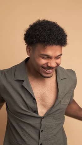 surprised man with cellphone celebrating victory in beige studio