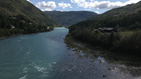 Aerial-drone-forward-moving-shot-flying-over-the-Otta-river-in-Lom,-Norway-on-a-cloudy-day