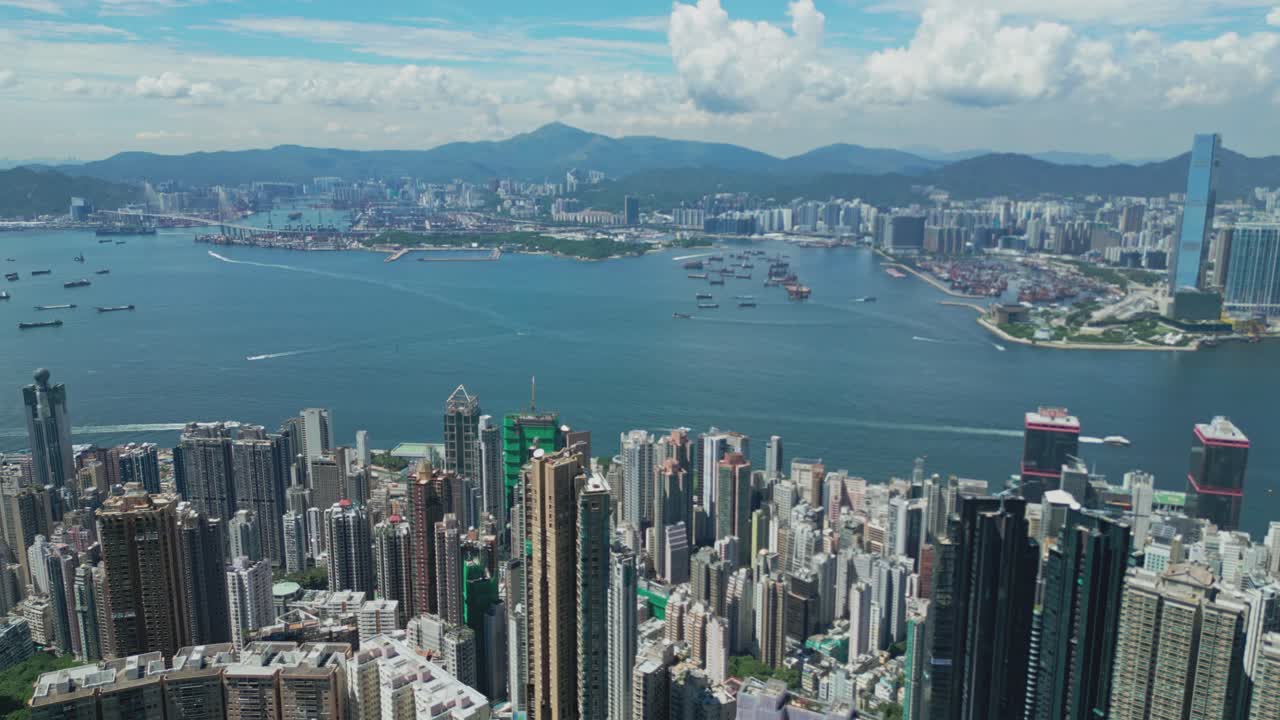 Aerial drone footage capturing Hong Kong harbour with city skyline, bustling vessels, and waterfront views, highlighting maritime transport, urban architecture, and iconic coastal landscapes