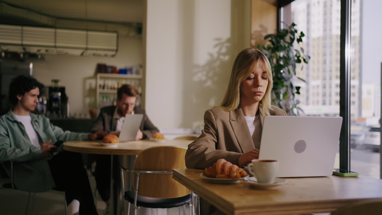 Una donna che lavora su un portatile in un caffè