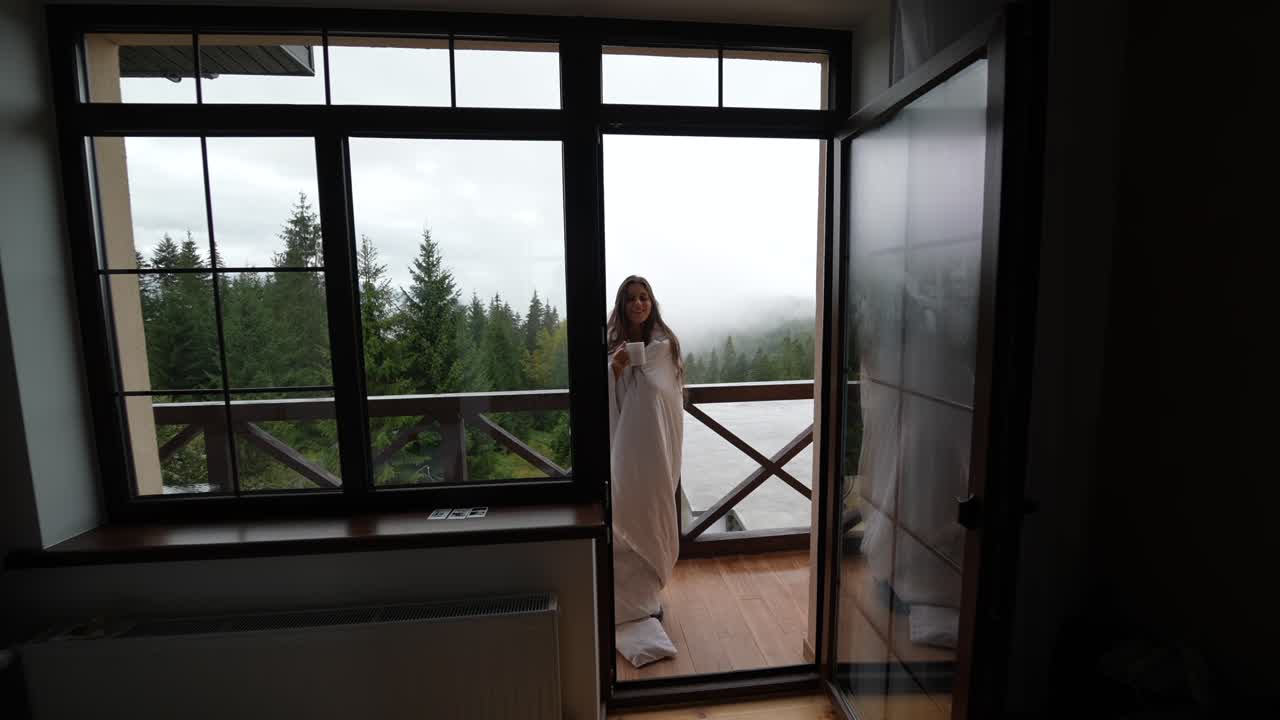 женщина наслаждается кофе на балконе с видом на горы