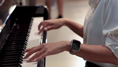 hands playing notes on a piano keyboard