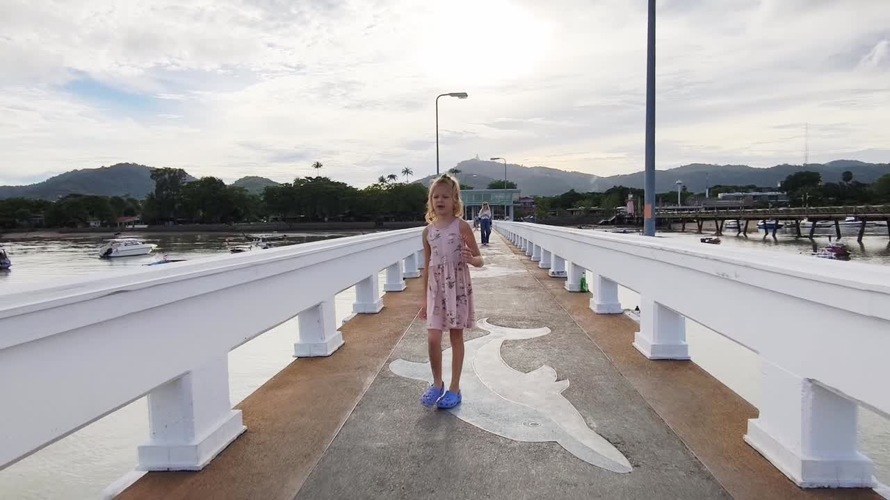 Young Girl Walking on a Pier by the Ocean