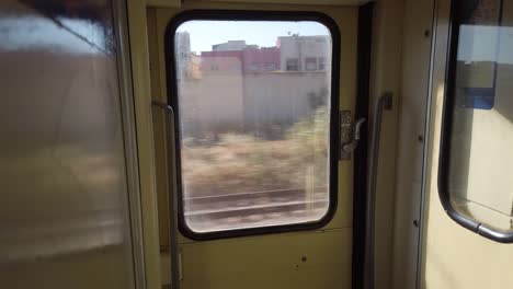 view of buildings from the window of a train running near rabat in morocco