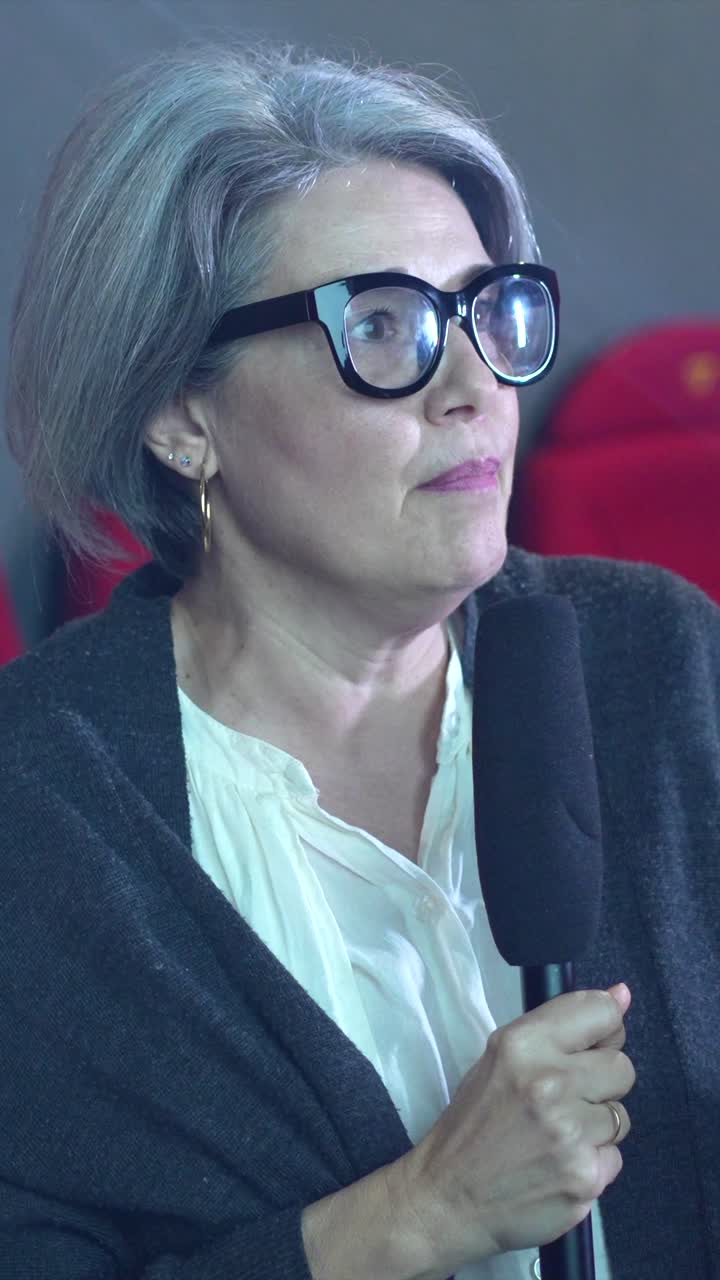 A woman with gray hair speaking into a microphone