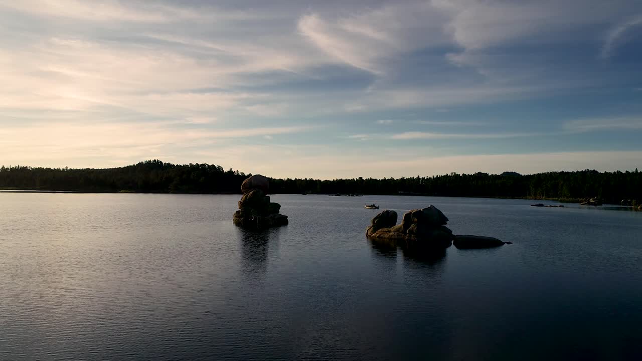Una minuscola barca appare alla fine di questa bellissima clip ricca di riflessi dorati, verde acqua, arancioni e blu intensi