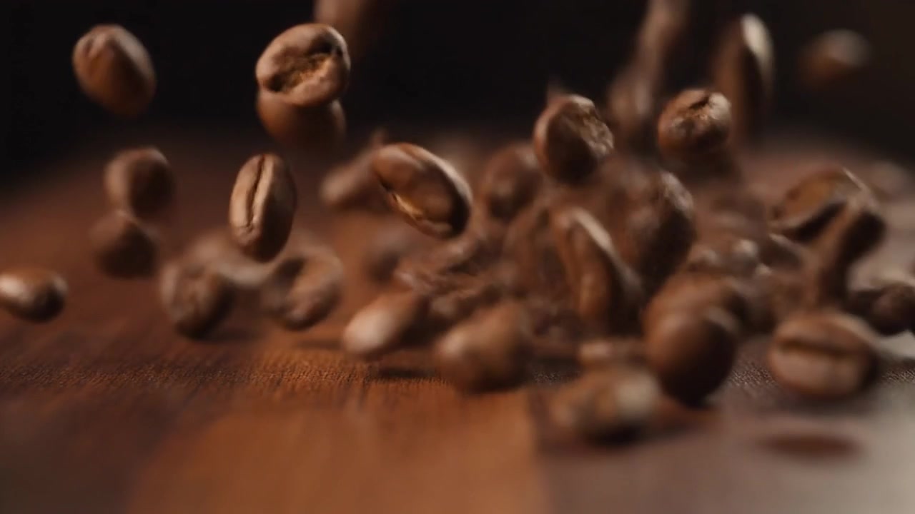 Ristede kaffebønner falder ned på en træoverflade