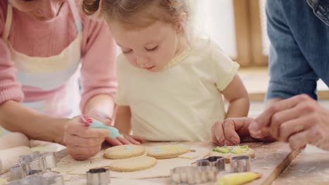 Handheld-view-of-child-decorating-cookies-under-watchful-eye-of-parents