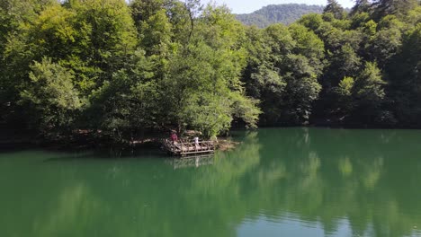 Lake-In-A-Wooded-Park-Low-Aerial-Shot