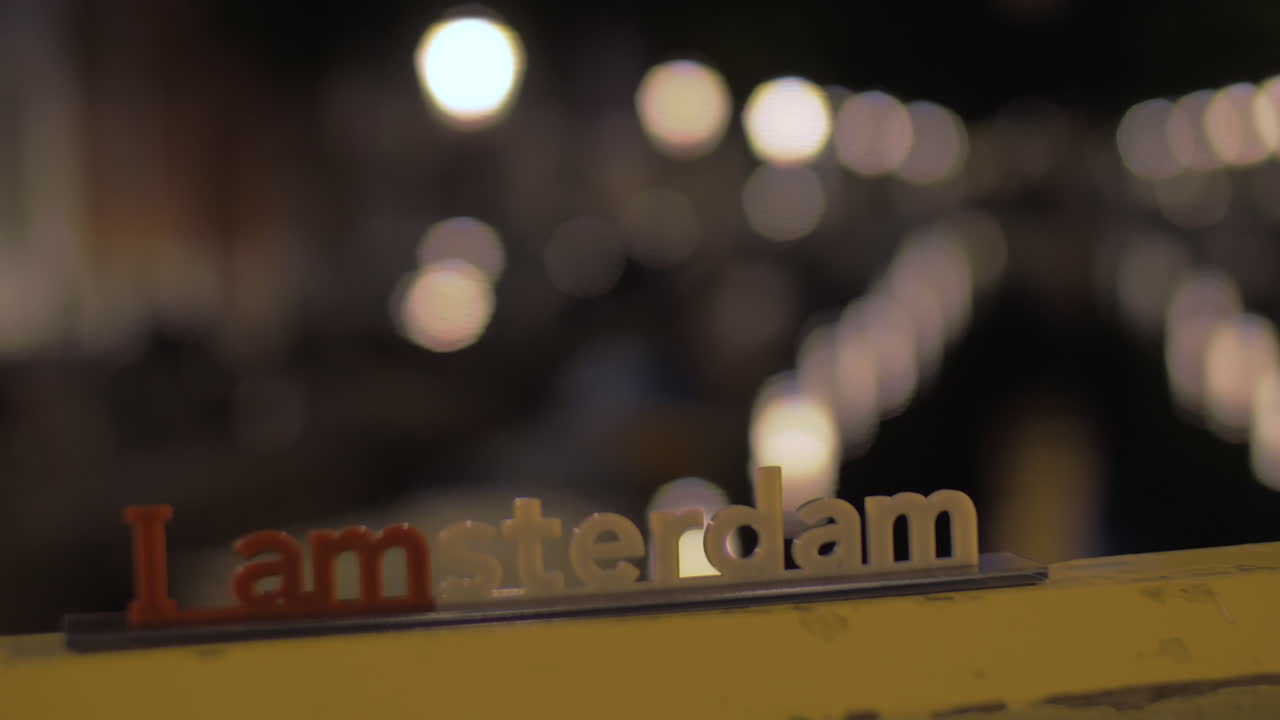 운하와 암스테르담 슬로건을 가진 야간 도시 전망