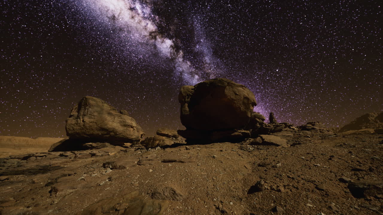 Explore the breathtaking beauty of the night sky over a desert landscape