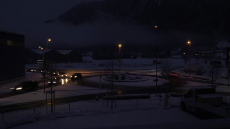 day to night timelapse of cars driving around a roundabout while heavy snowfall in switzerland