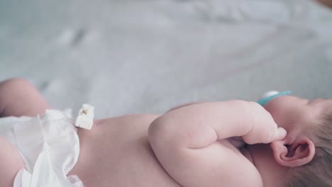 mother hand calms down restless infant with short fair hair