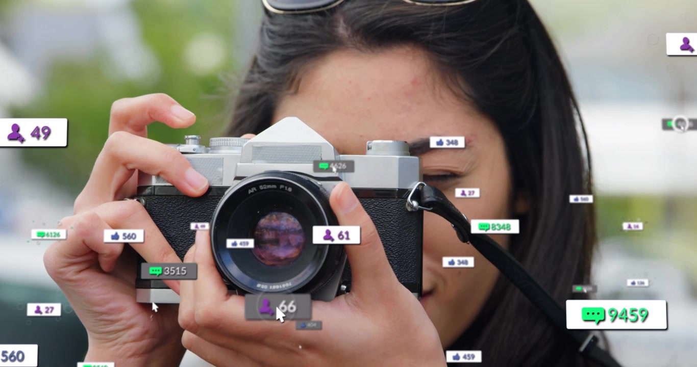 ช่างภาพหญิงกำลังยกกล้อง SLR วินเทจ ทำให้เกิดตัวนับโซเชียลรอบเลนส์ ขณะตรวจสอบภาพถ่าย