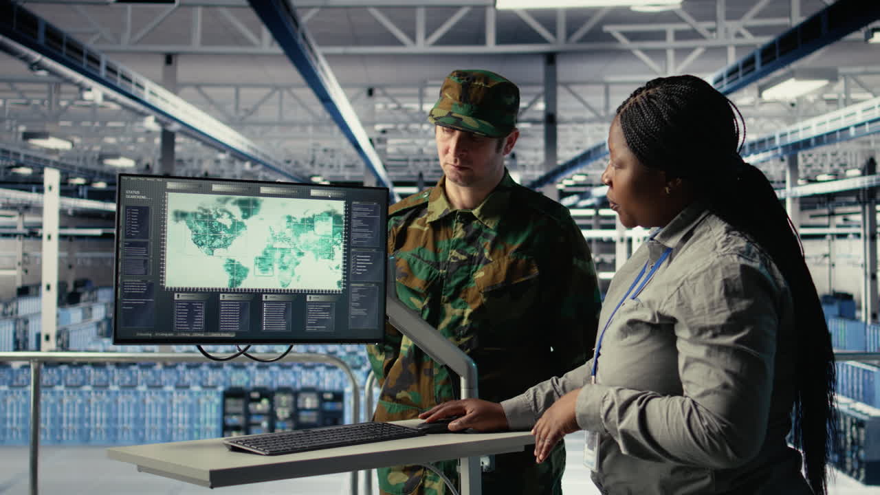 Team Of Military Specialists In Data Center Looking At World Map On Screen