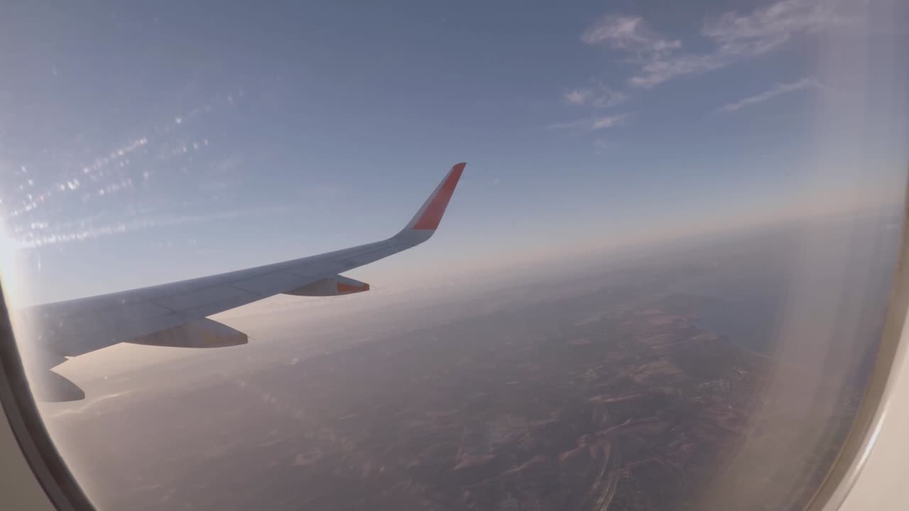 비행기 날개가 있는 창가 좌석과 창문을 통해 약간의 햇빛이 비치는