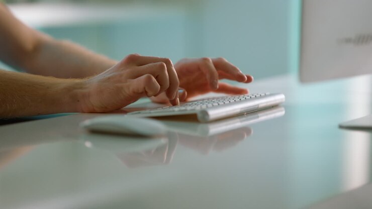 Journalist hands typing article in office closeup. Unknown man working computer