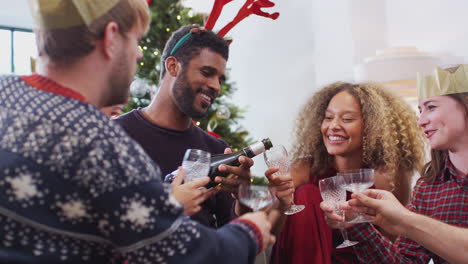 Gruppe-Von-Freunden,-Die-Mit-Champagner-Feiern,-Nachdem-Sie-Das-Weihnachtsessen-Zu-Hause-Genossen-Haben