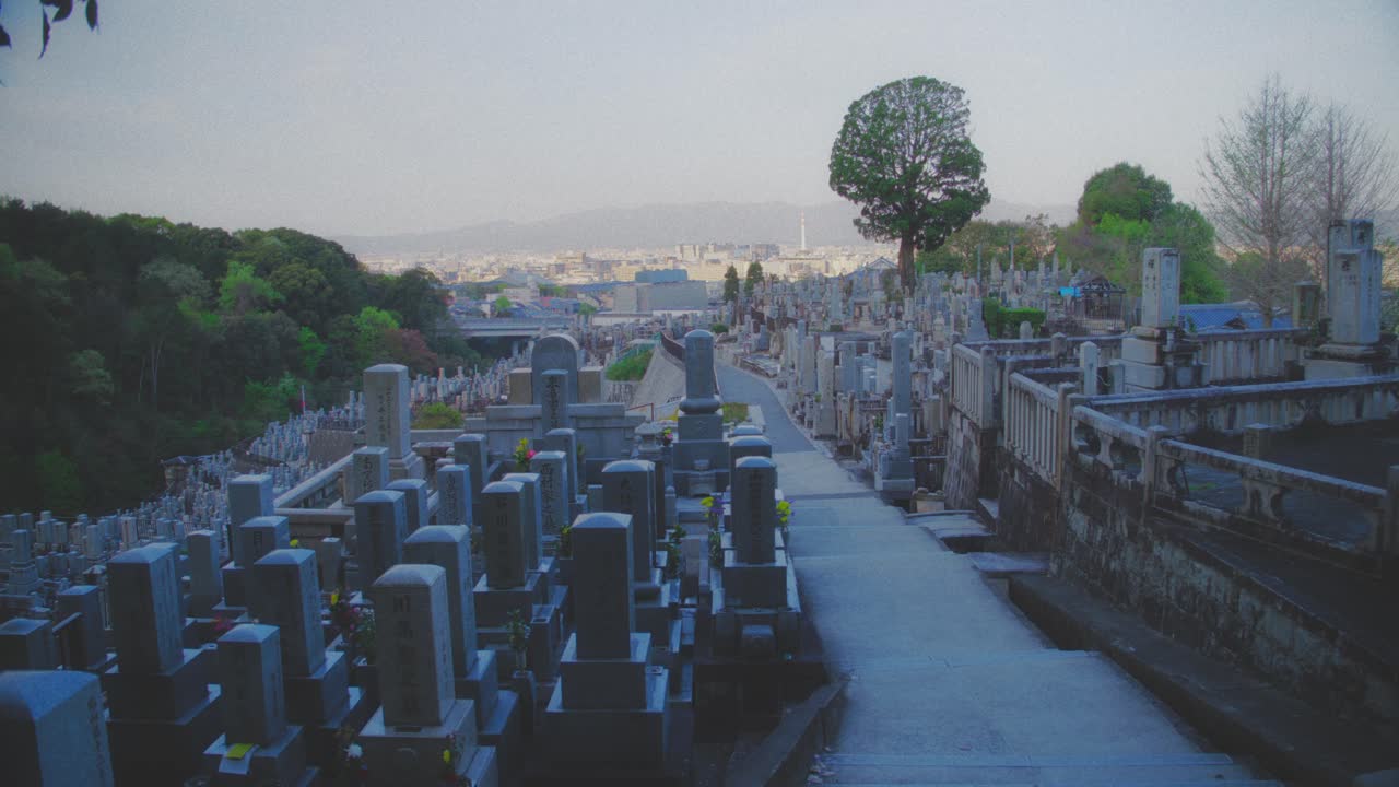 Scenic view of a peaceful cemetery overlooking the city of Kyoto under the soft morning light, capturing tranquility and reflection.