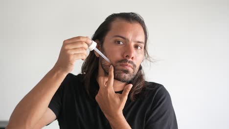 Hombre-Aplicando-Minoxidil-A-Su-Barba-Con-Un-Gotero,-Fórmula-Líquida