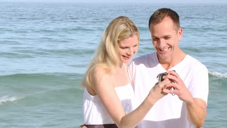 close up of couple on the beach taking photos of themselves