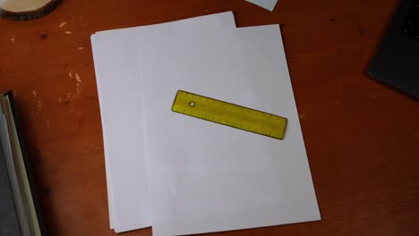 transparent small ruler is placed on a table on white paper and taken away again