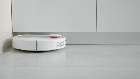 primer plano de un robot aspirador conduciendo en el suelo