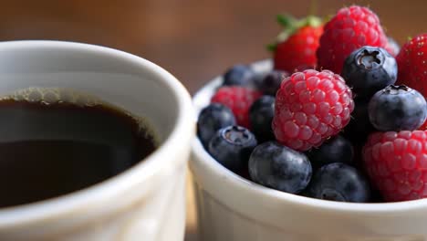 a delicious morning encounter: a close-up of fresh berries accompanied by a perfectly brewed cup of coffee, inviting indulgence and flavorful start to your day