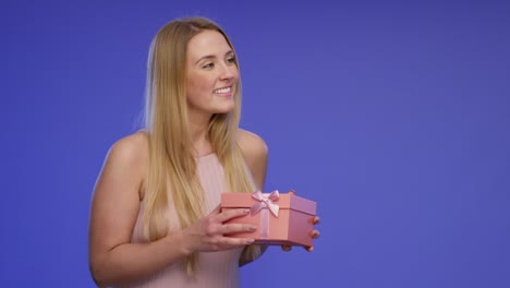 manos están dando una caja de regalos a una mujer joven hermosa y impresionante y ella está satisfecha