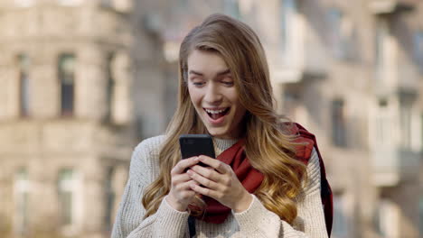 surprised woman surfing internet by phone outside. excited woman reading message