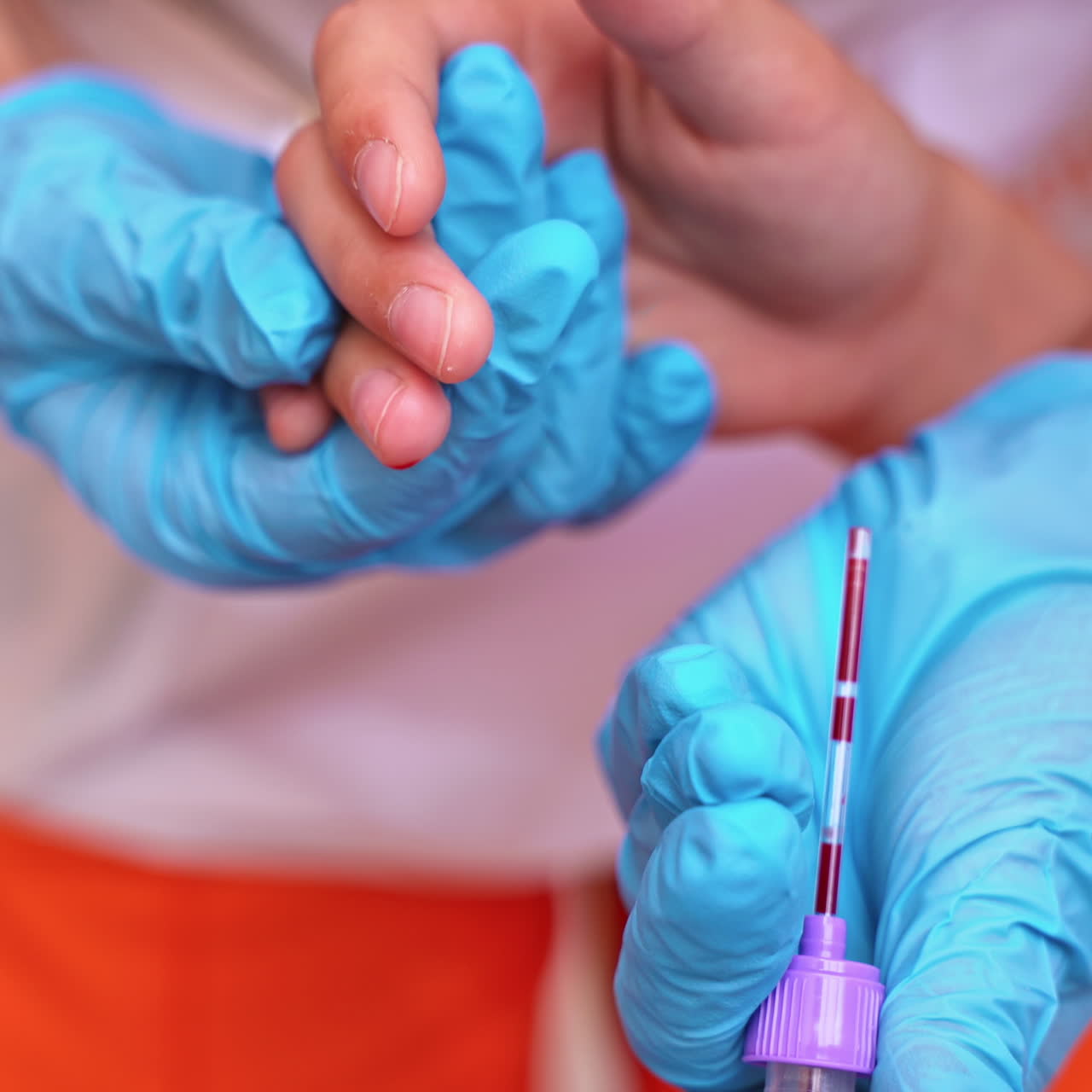 Medical worker taking blood sample. Hands in blue sterile gloves collecting blood from patient's finger. Close-up. Blood test.