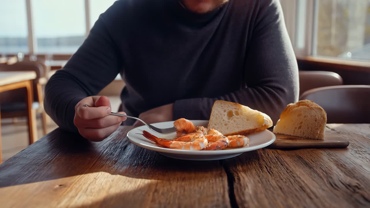 Person Eating Shrimp and Bread at a Restaurant