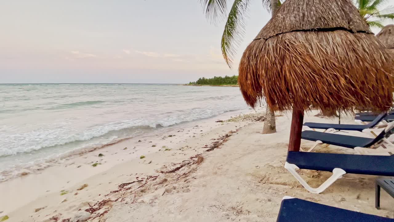 el complejo de playa de trs en tulum, méxico, muestra las cabañas con mesas, sillas y palmeras.