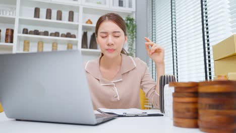 depressed asian female feel worried about financial problem in business. stressed desperate bautiful woman frustrated to sale order in book and think of money debt, budget loss, bankruptcy at store.