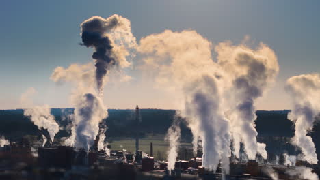 smokestacks emit hazardous greenhouse gases at power plant, dramatic drone view