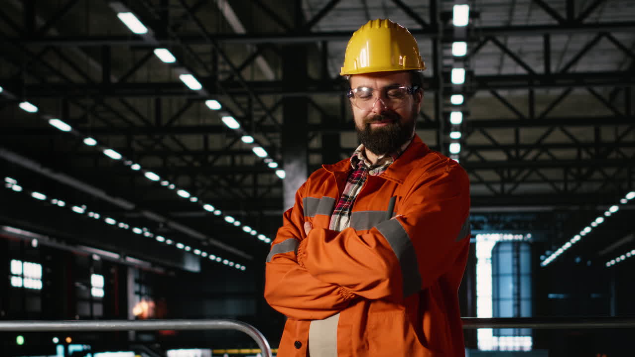Ritratto di personale con casco e occhiali di sicurezza che esamina un progetto industriale.