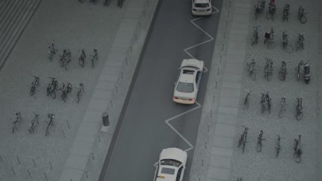 cabs in a line pull in and park at train station, waiting for passengers