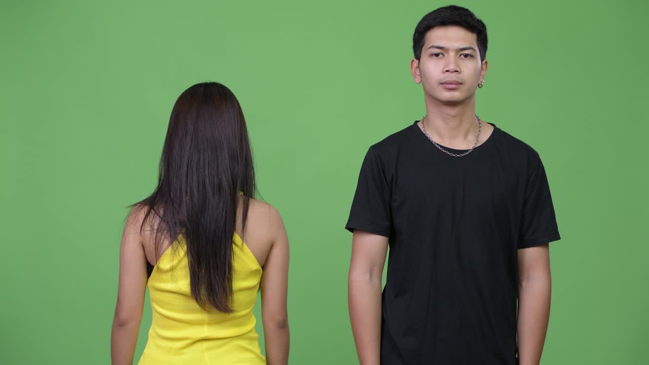 Young Asian man with young Asian woman looking at the back