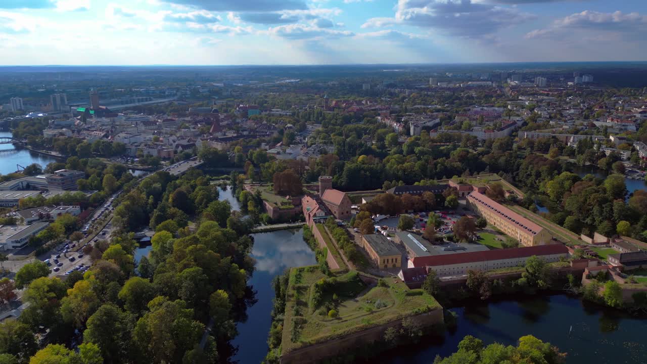 Spandau Citadel, an imposing Renaissance fortress surrounded by water, stands under a clear sky. Lovely aerial view flight circle drone footage