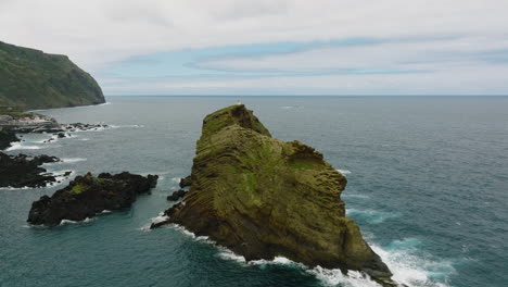 arco aéreo alrededor del escarpado topo de ilheu, faro de porto moniz en la cima