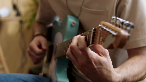 young man practising with the guitar