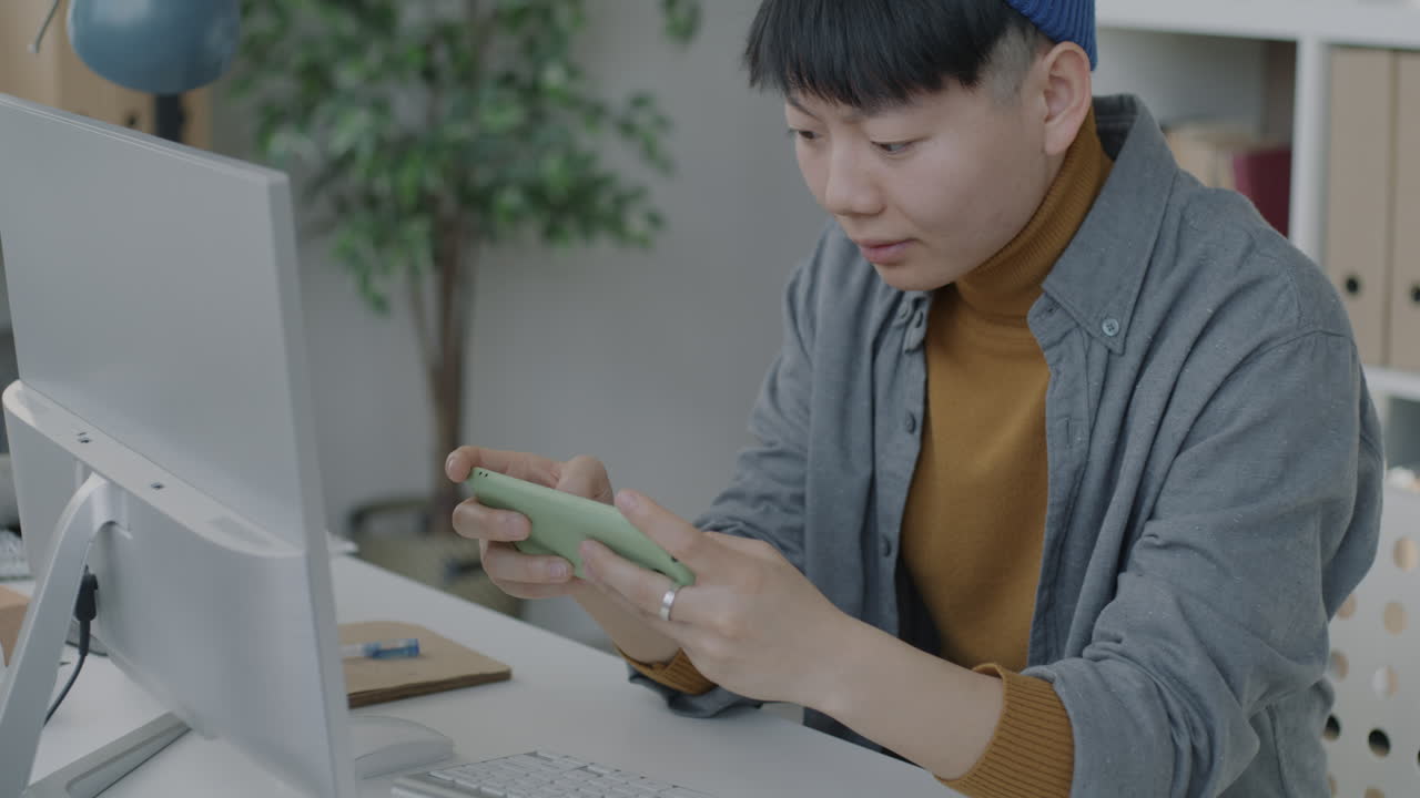 Young Person Using Smartphone and Computer